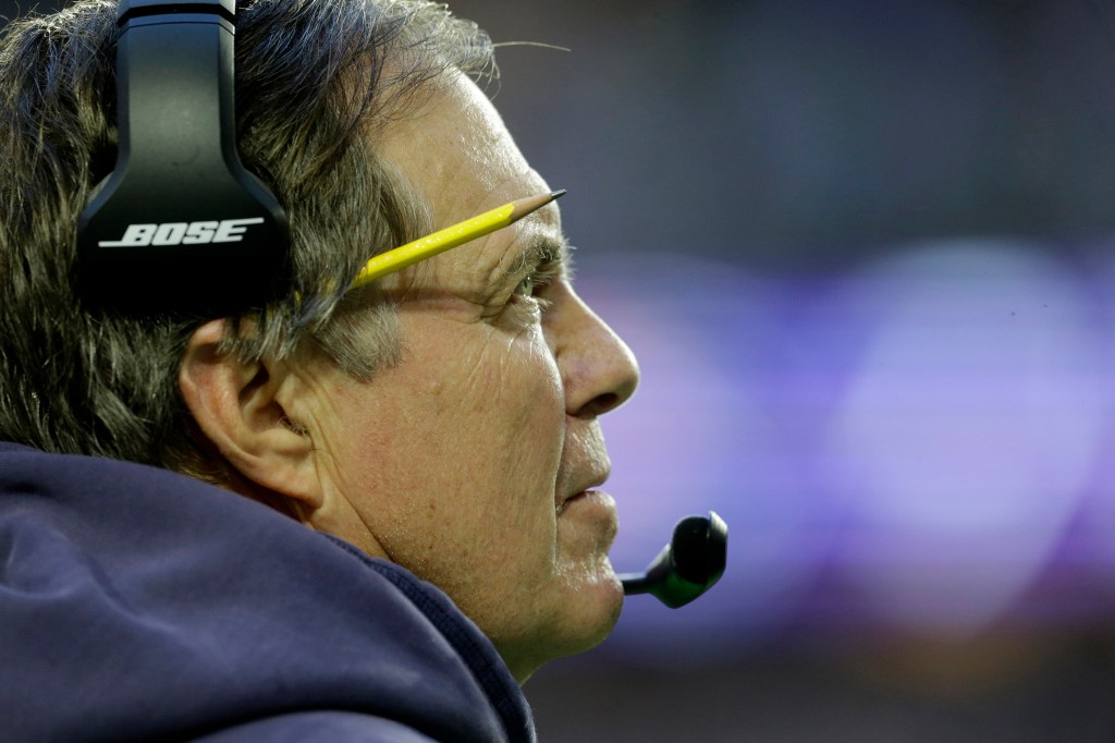 Patriots coach Bill Belichick wears headset on the sidelines during the first half of NFL Super Bowl XLIX.