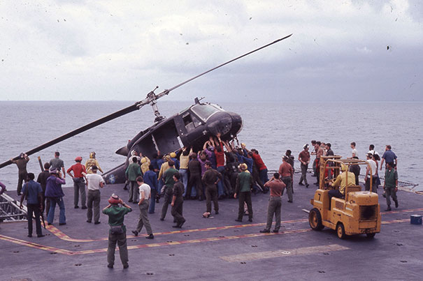 Crew members aboard the USS Okinawa push a South Vietnamese helicopter overboard to make room for incoming flights filled with evacuees Saigon fleeing the Vietcong.