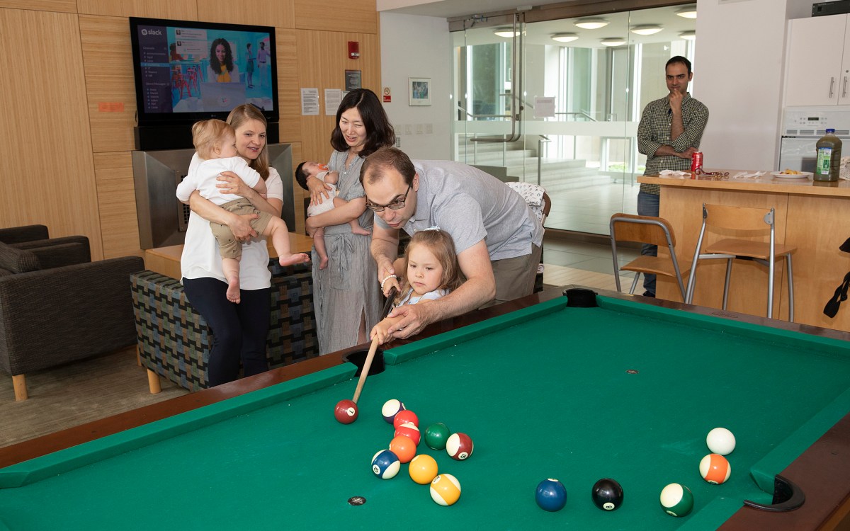 family playing pool at grad commons