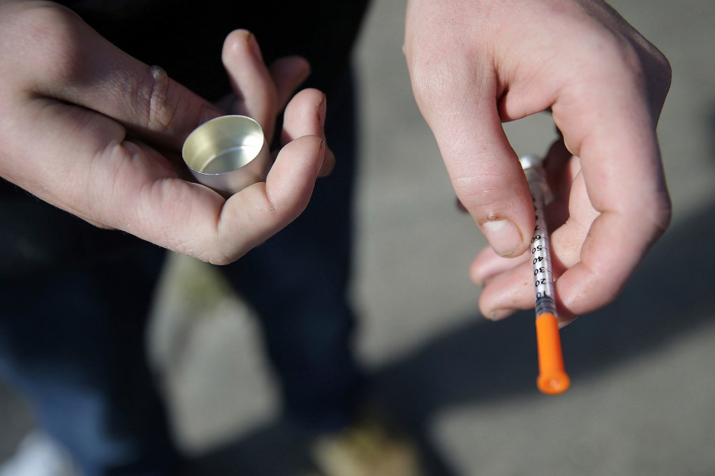 A fentanyl user holds a needle.