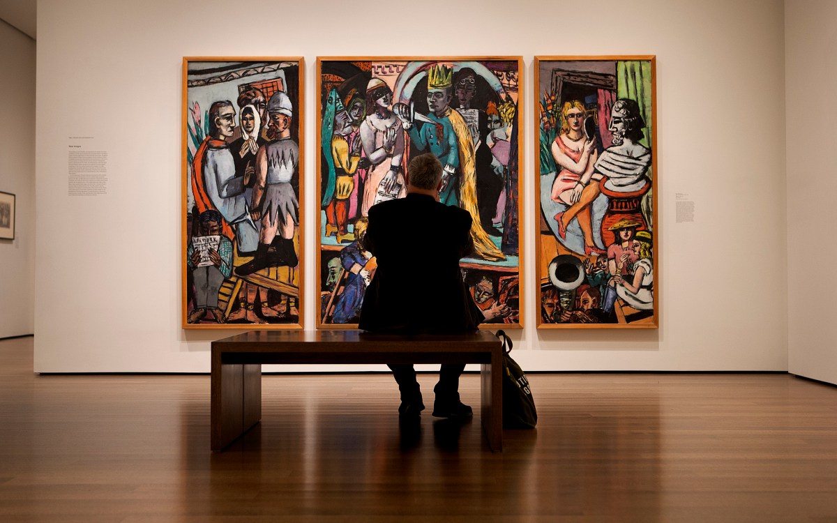 A visitor takes a photo of a painting on the wall at the Harvard Art Museum.