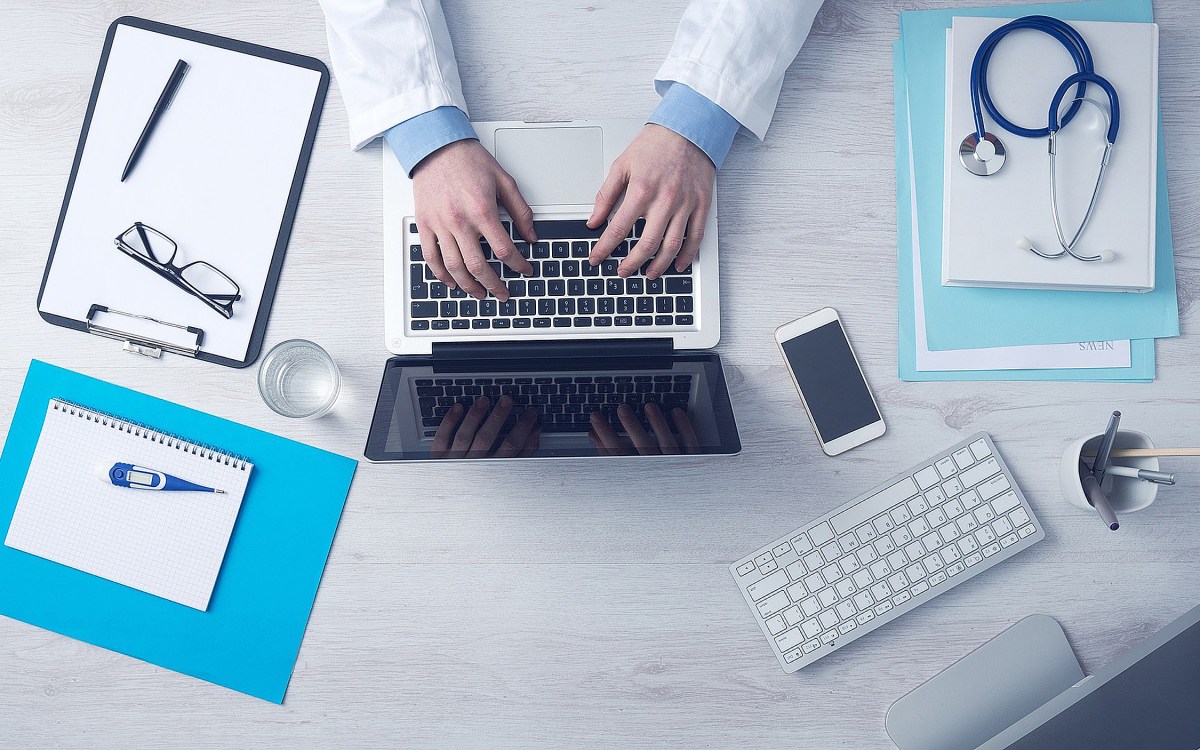 Overhead view of a doctor working on a laptop