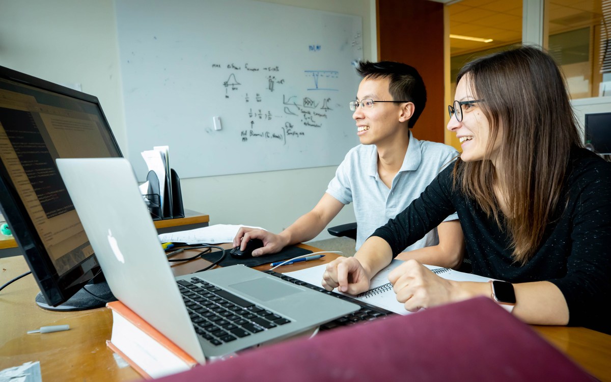 Two researchers looking at a computer.