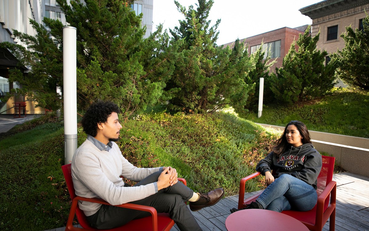 Two Harvard alums sitting in chairs