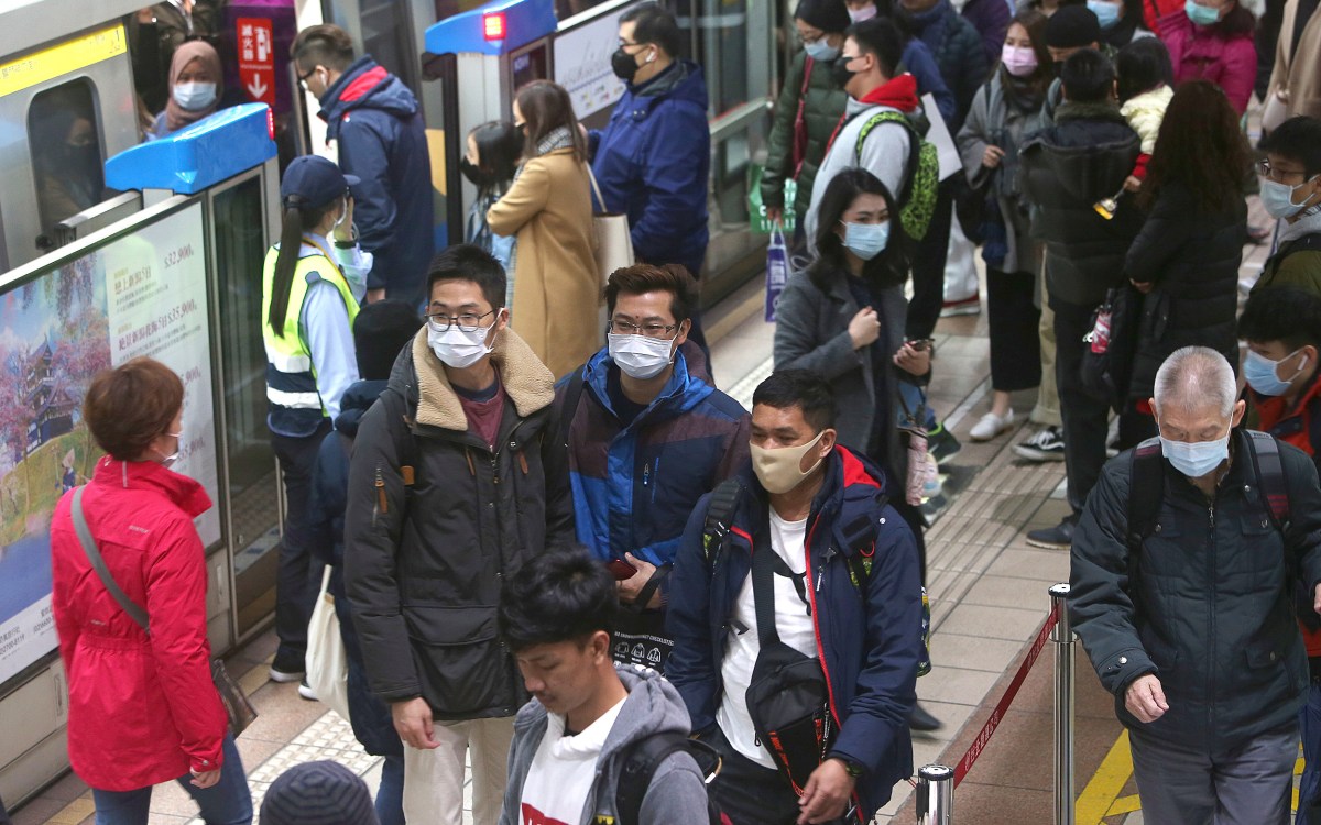 People with masks on at a Chinese metro station.