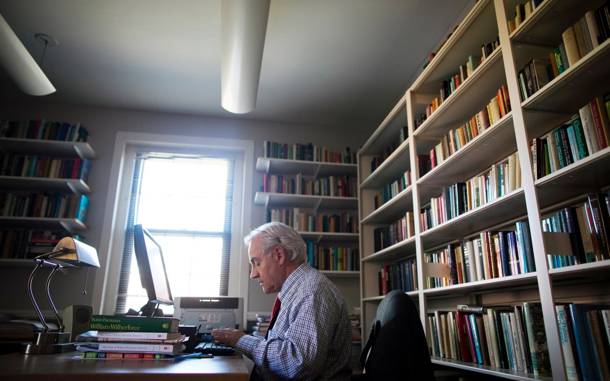 E.J. Dionne typing in his office.