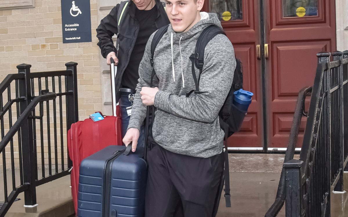 Two students with suitcases.