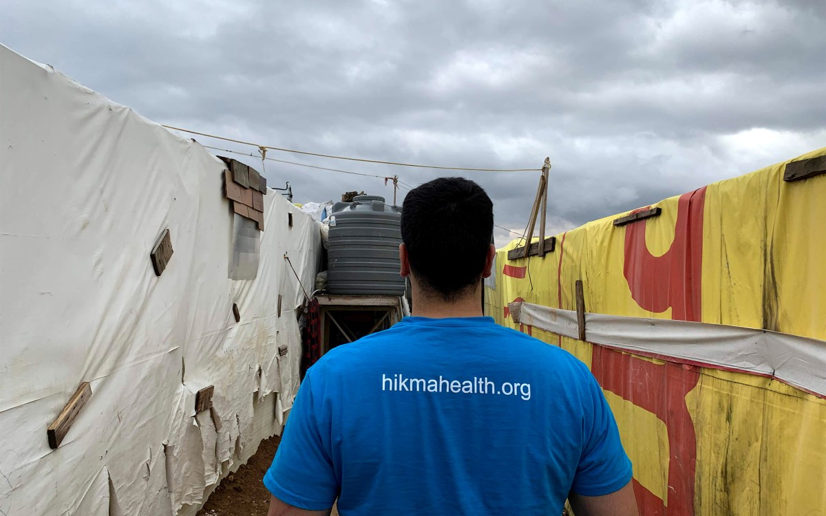 Man walking between tens in refugee camp.