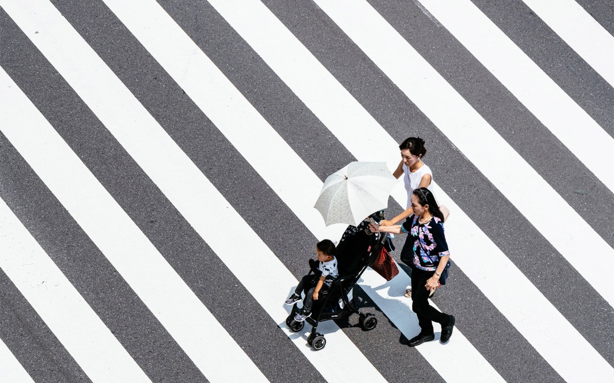 Asian family wzaalking across street.