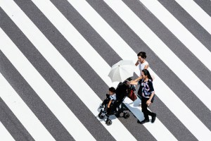 Asian family wzaalking across street.