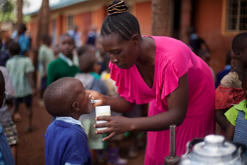 Giving a child medicine.