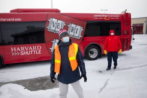 Two Harvard transportation people with bus.