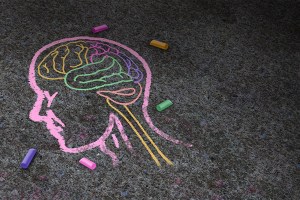 Concept of autism and autistic development disorder as a symbol of a communication and social behavior psychology as a chalk drawing on asphalt in a 3D illustration style.