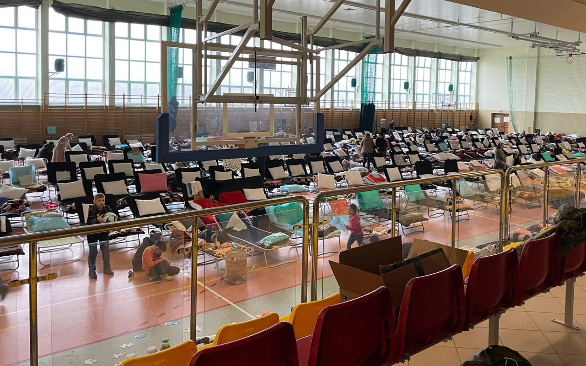 Beds set up in gymnasium turned refugee center.