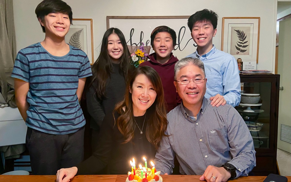 Elijah Suh, his siblings, and parents pose in front of birthday cake.