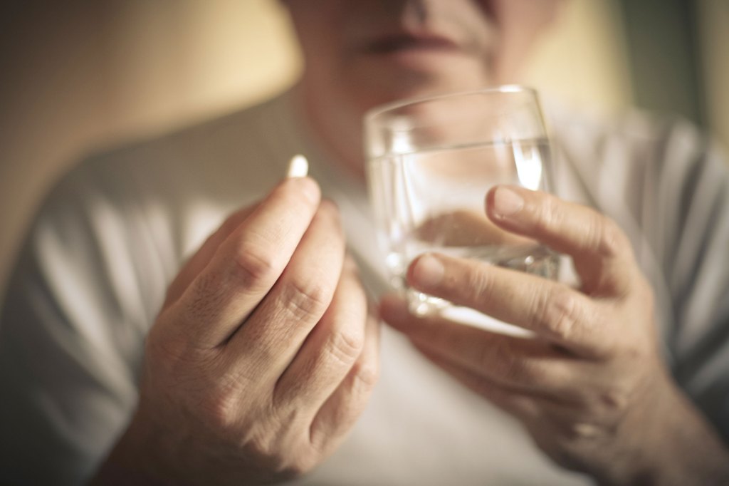 Man taking a vitamin.