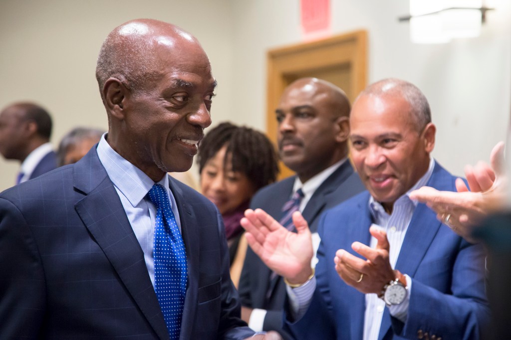 Charles Ogletree walks past crowd of well-wishers including an applauding former Massachusetts Governor Deval Patrick.