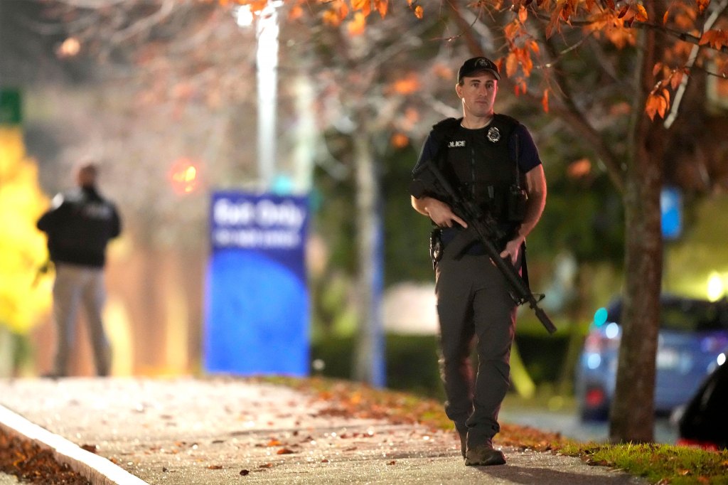 Law enforcement officers carry rifles outside Central Maine Medical Center.