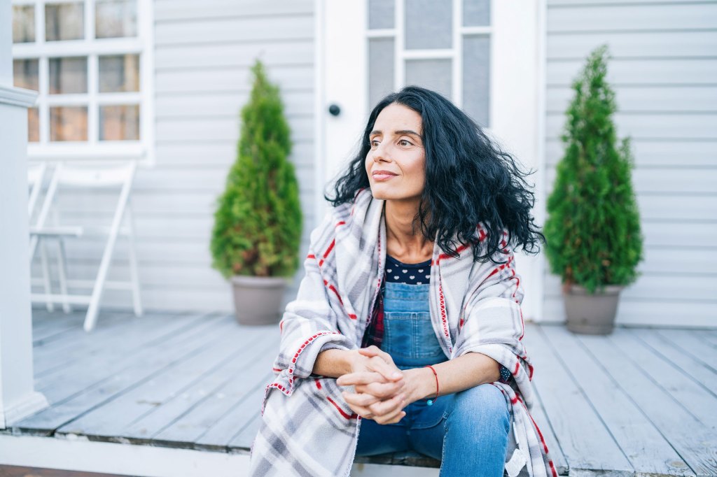 Sad woman sitting on porch.