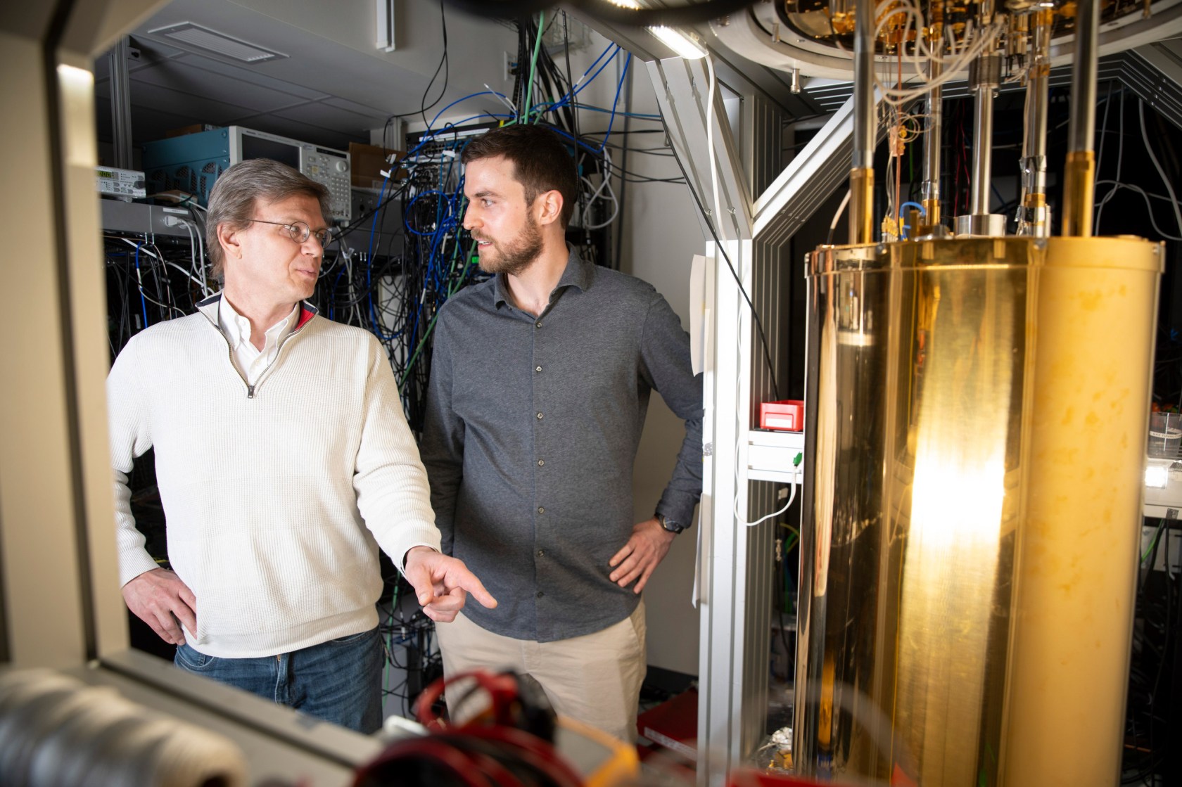 Mikhail Lukin (left) and Can Knaut stand near a quantum network node called a diamond silicon vacancy center.