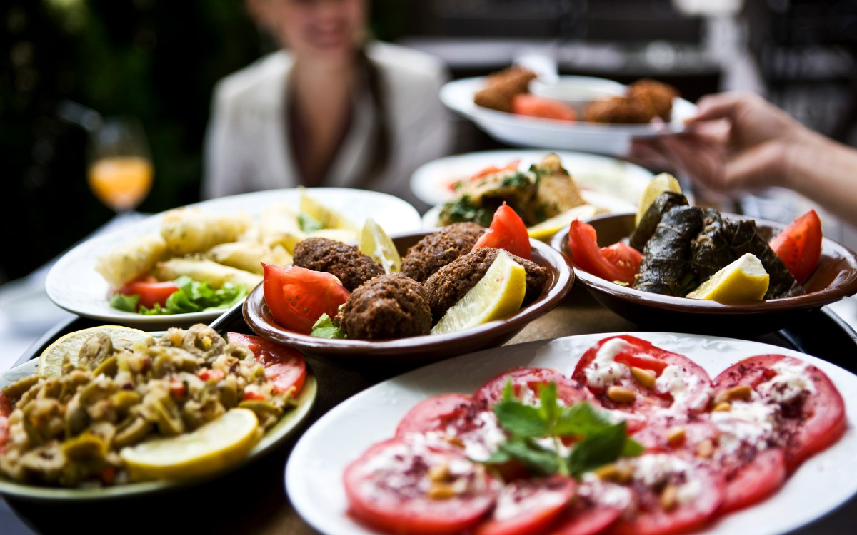 Woman being served food from the Mediterranean diet.
