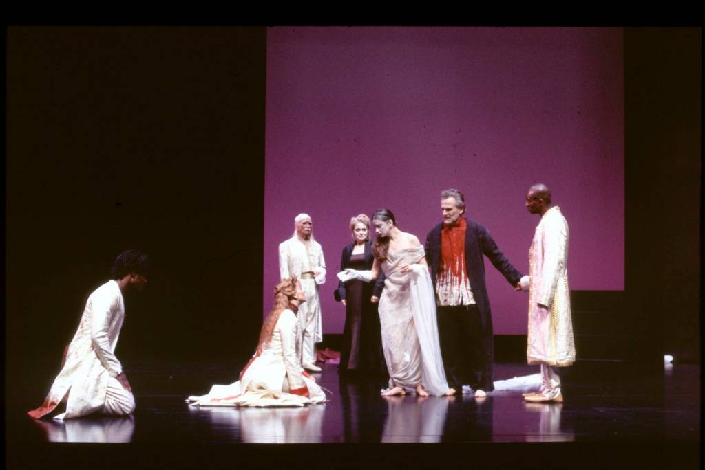 A woman kneeling in front of a group of people. 