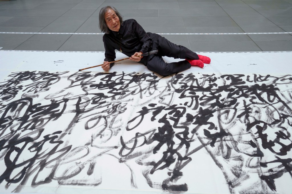 Dongling sitting with his finished calligraphy piece.