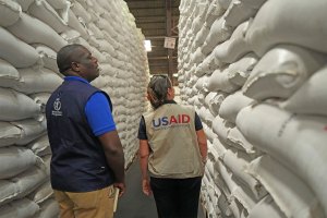 Officials from USAID and WFP inspect a donation of $11 million worth of food aid.
