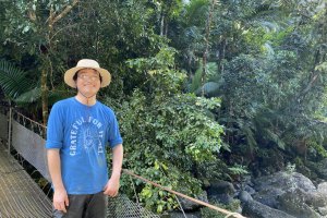 Shaoqing Liu standing in a tropical forest.