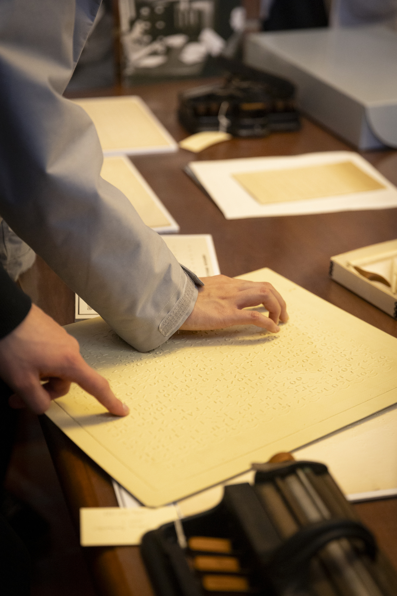 Students feel the braille writing on an example sheet provided. 