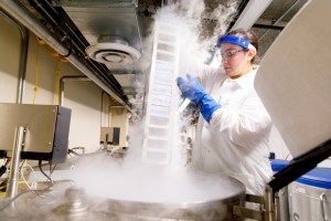 Researcher removes biological samples from freezer.