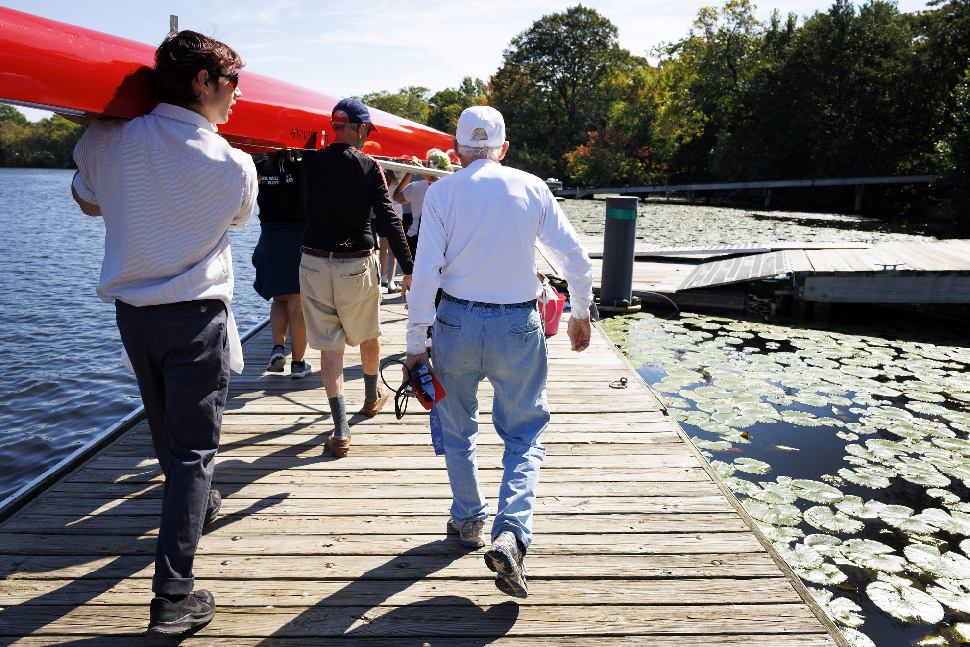 Bill Becklean, the 89-year-old coxswain for the Octo Eight, walks alongside the boat to the boat house after practice.