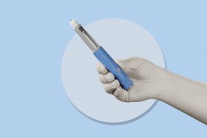 Hand holding semaglutide injection pen.