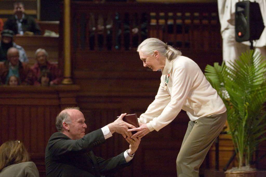 Richard W. Wrangham (left) helps Jane Goodall (right) open the award box.