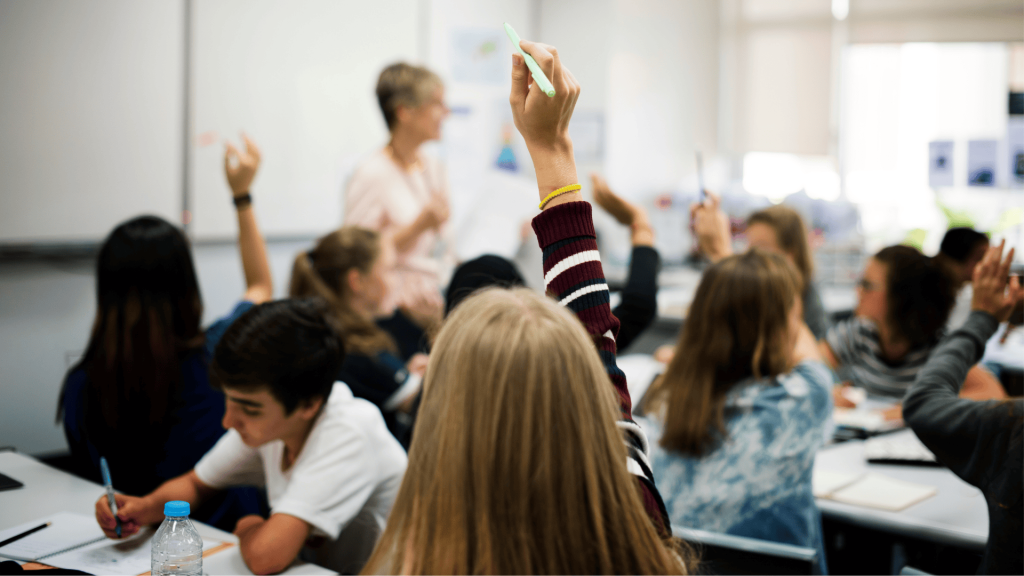 girl raising her hand in a classroom