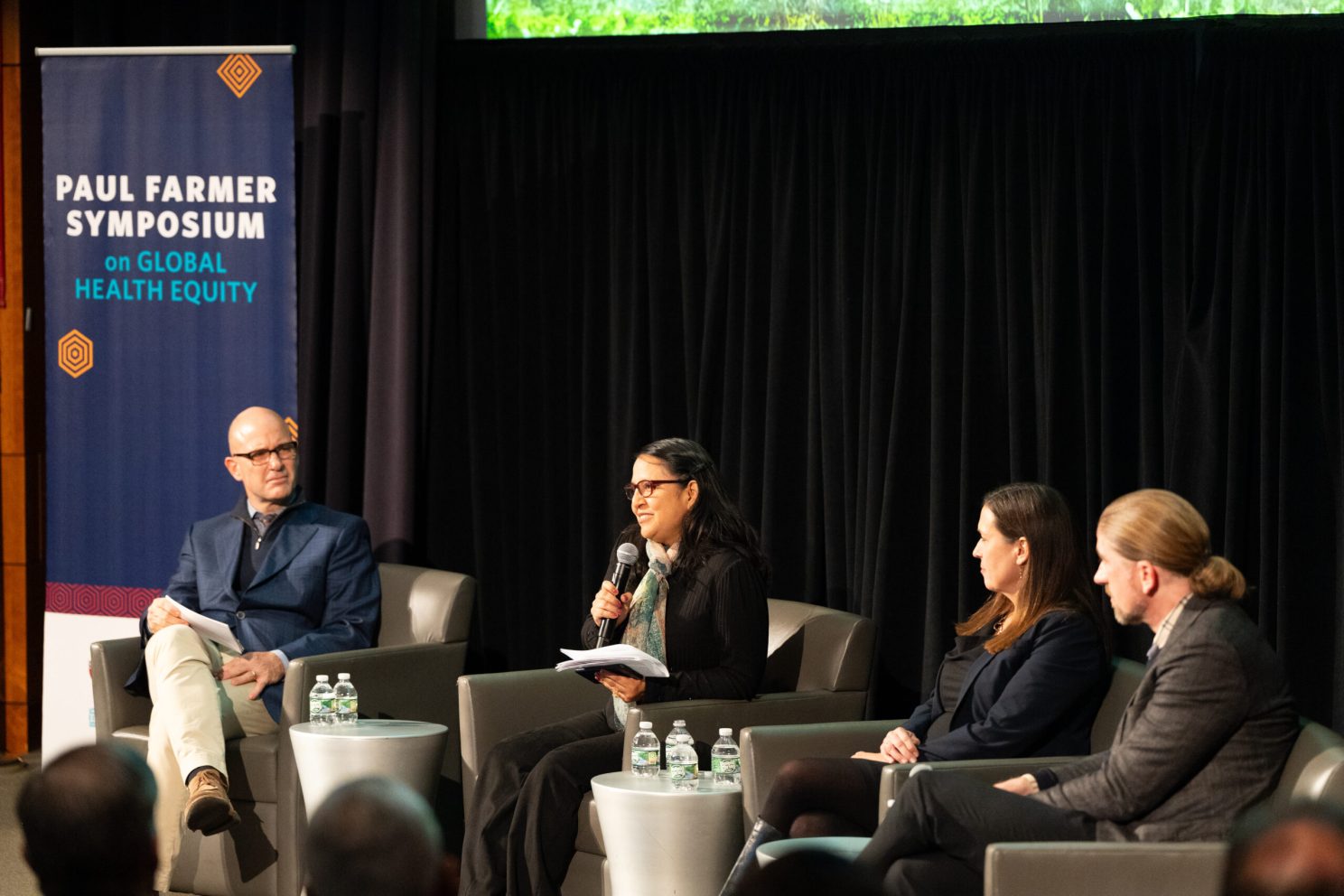 Moderator Giuseppe (Bepi) Raviola (fom left), followed by panelists Carmen Contreras, Theresa Betancourt, and John Naslund speaking on the first panel at the Paul Farmer Symposium on Global Health Equity.