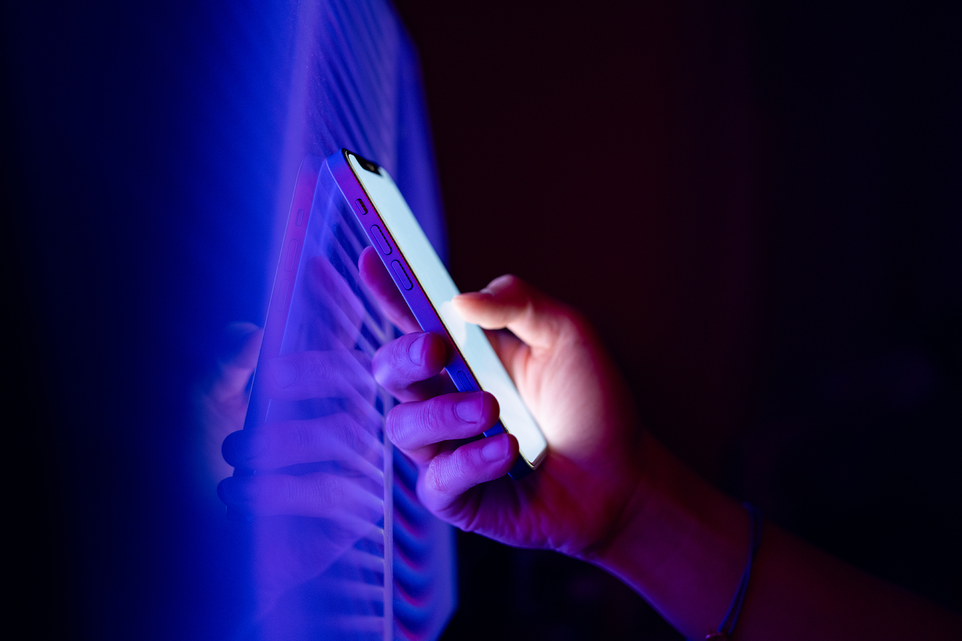 Person holding a smartphone in the dark.