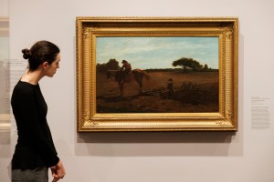 An attendee looking at Winslow Homer’s “The Brush Harrow,” 186