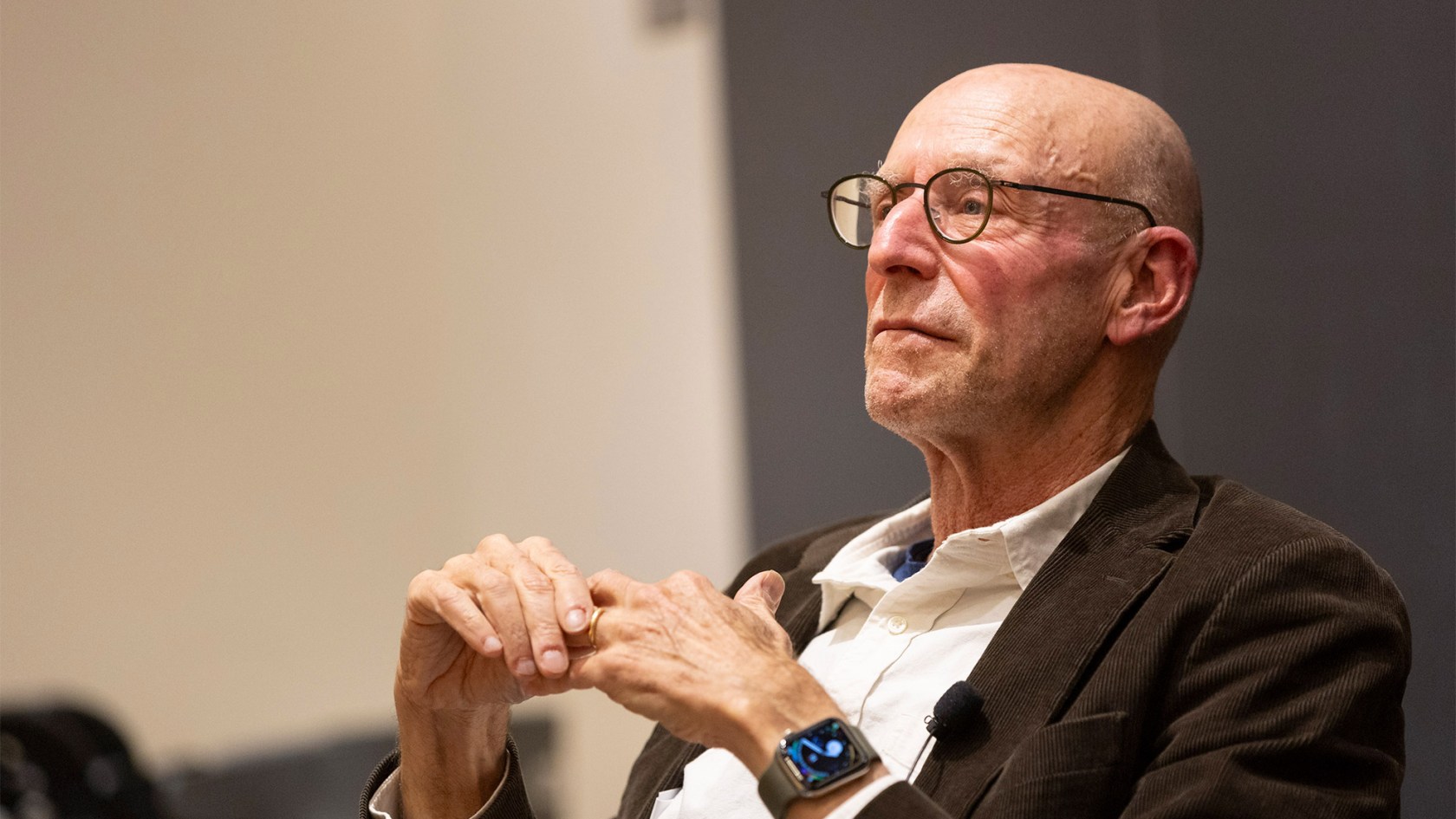 Michael Pollan sitting in a chair and listening.