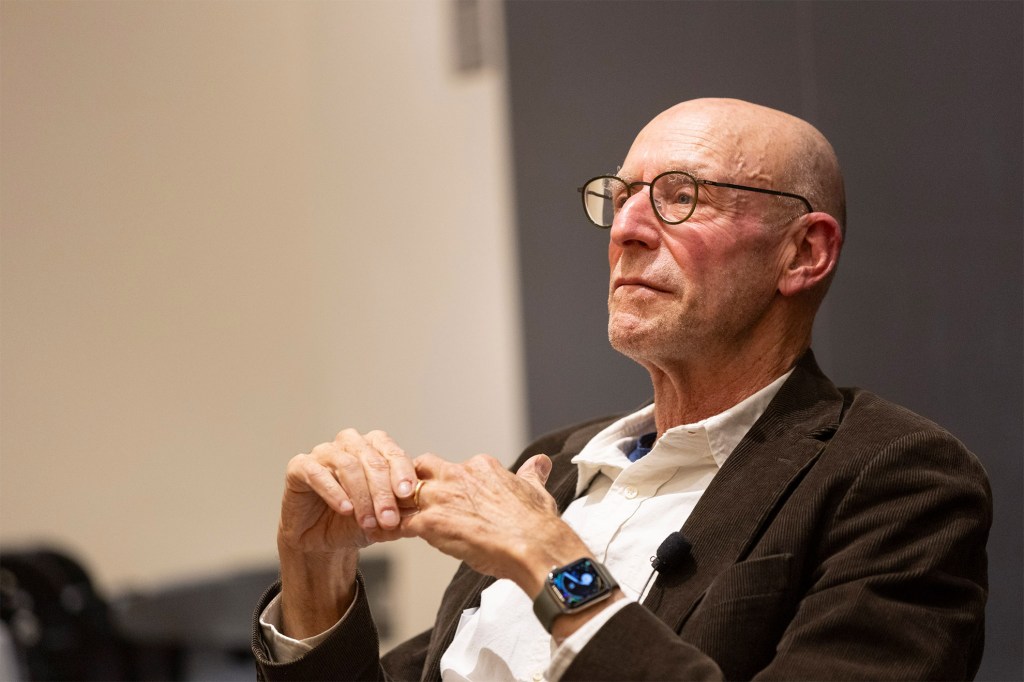 Michael Pollan sitting in a chair and listening.