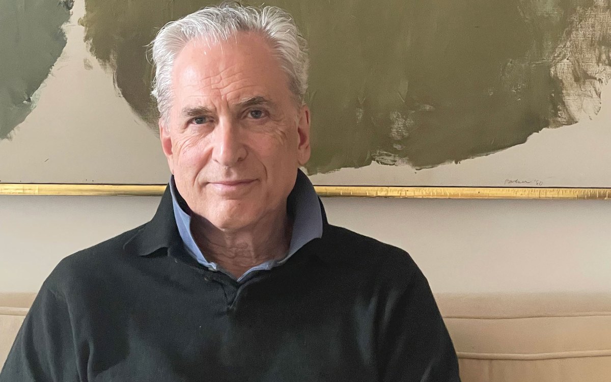 James Traub sitting for portrait with hands folded on lap.