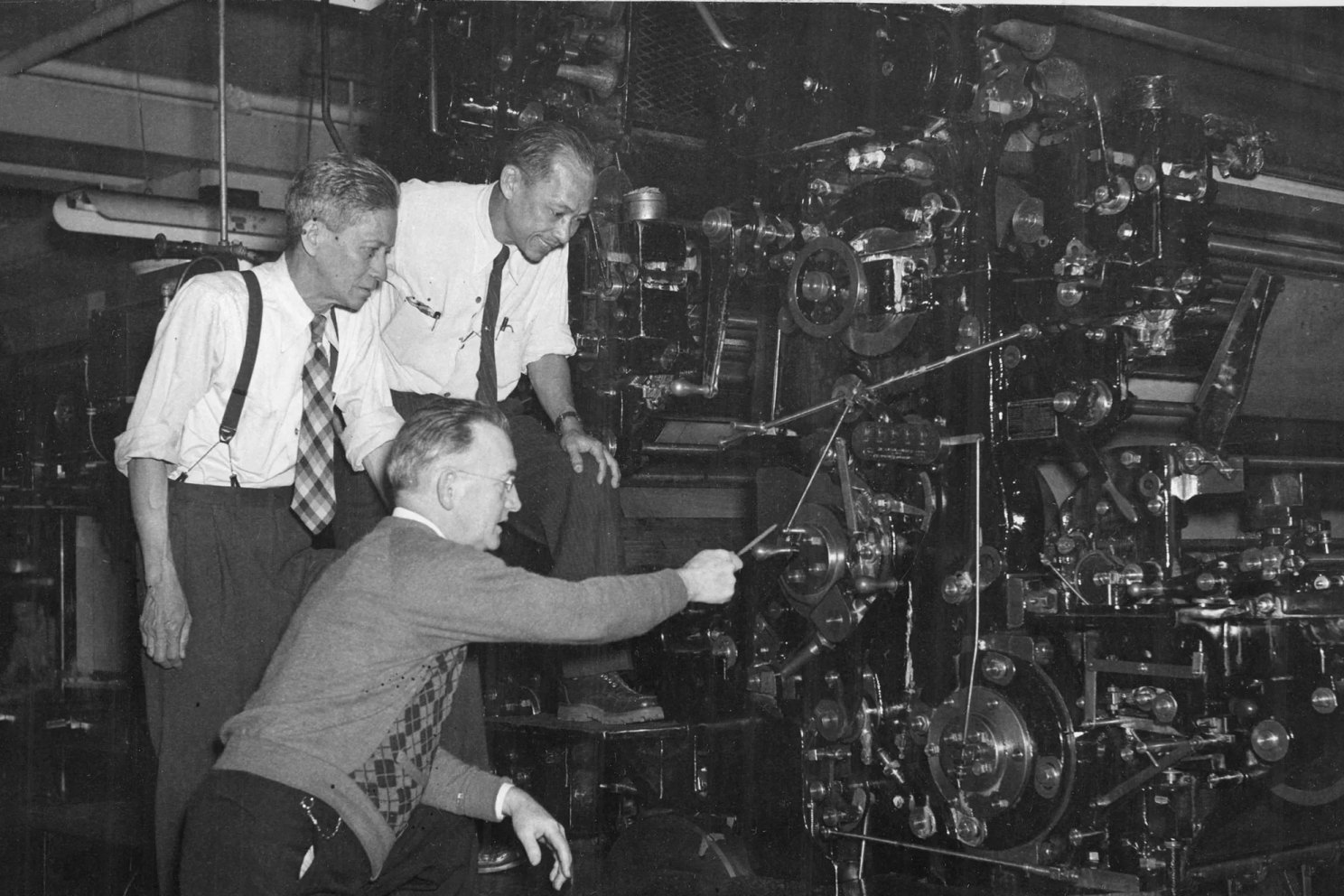 NOAA file photo with men looking at machine.