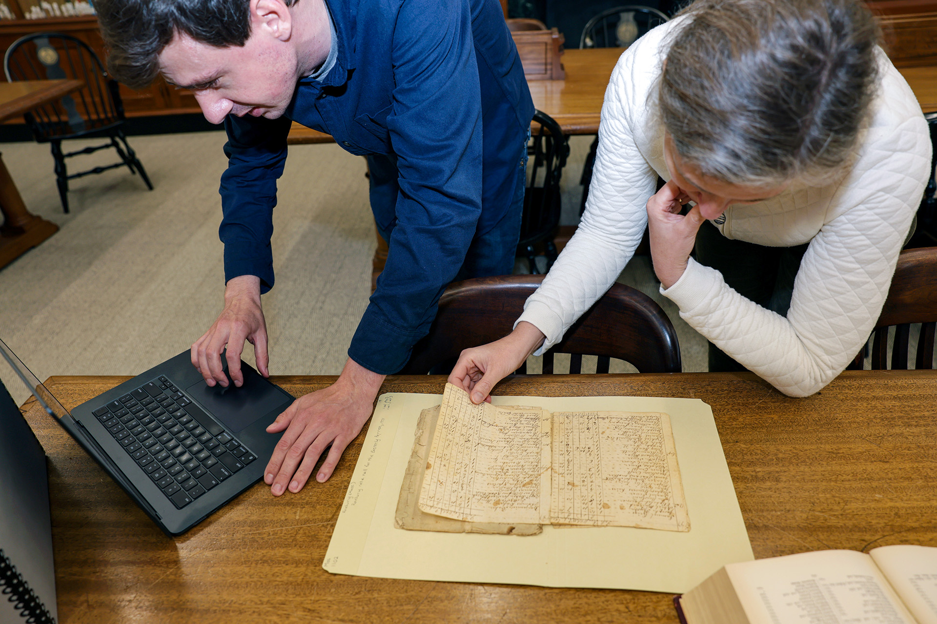 Gabriel Raeburn and Christine Bachman-Sanders inspect archival documents.