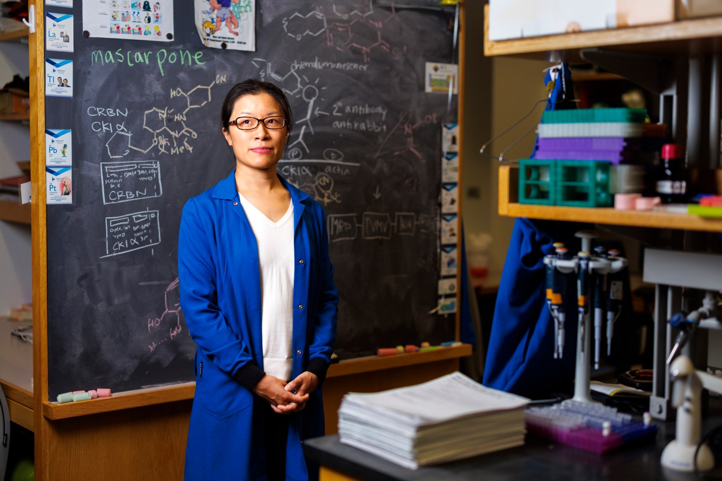 Christina Woo standing in front of a chalkboard.