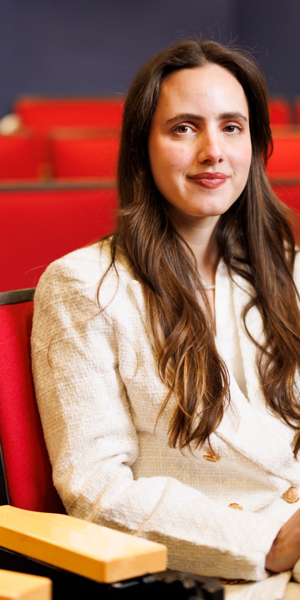 Luiza Lima Vieira sitting in a red theater seat.