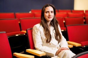 Luiza Lima Vieira sitting in a red theater seat.