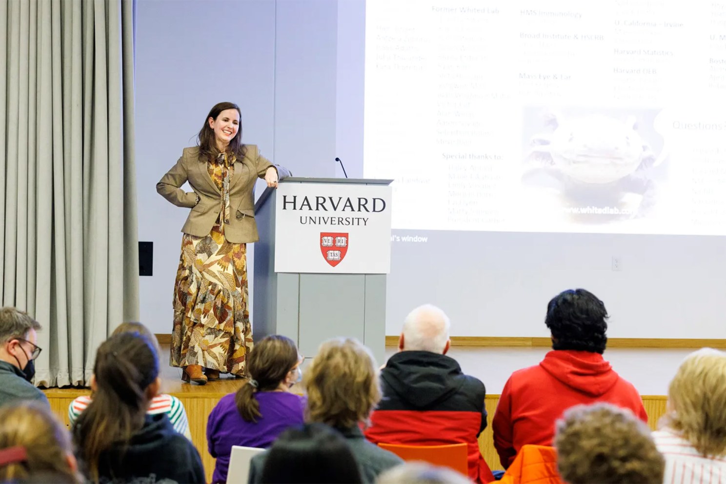 Jessica Whited, standing at a podium in front of an audience, presented the Rob Lue Memorial Lecture at the Harvard Ed Portal.